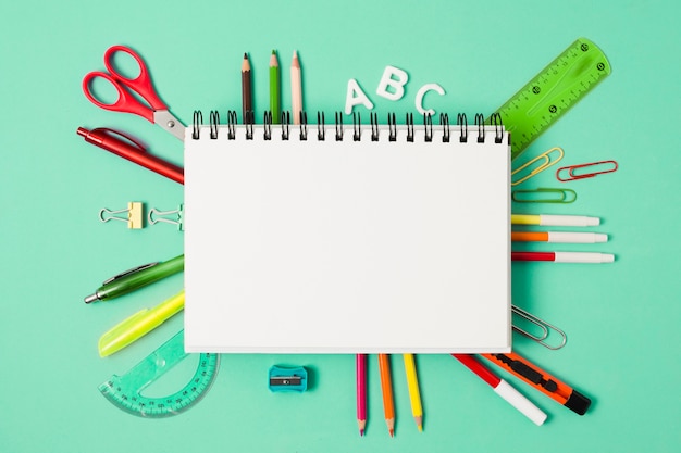 Blank notebook surrounded by stationery school supplies