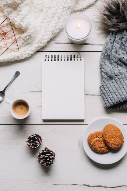 Free photo blank notepad with cookies on table