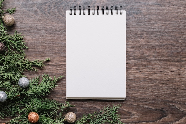 Blank notepad with green branches on table 