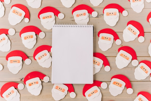 Free Photo blank notepad with small santa clauses 