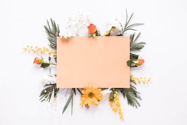 Blank paper on different flowers on table