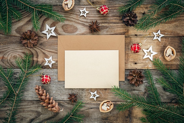 Free photo blank paper envelope and christmas decor on wooden background copy space