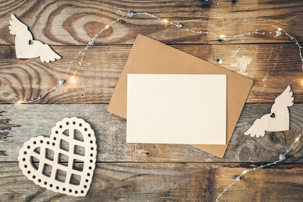 Free Photo blank paper and wooden heart on wooden background flat lay