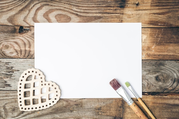 Free Photo blank sheet of paper and brushes for drawing on a wooden background flat lay