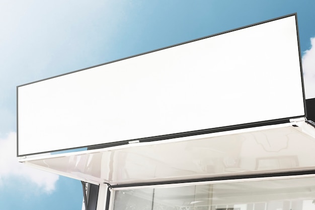 Blank shop sign against blue sky