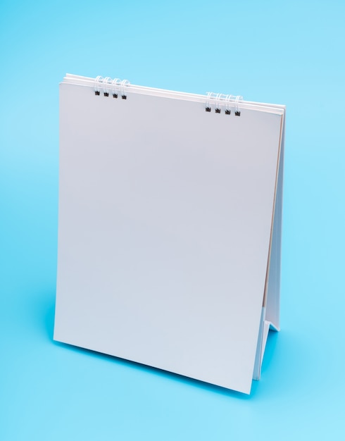 Blank table calendar with pages, isolated on blue background .