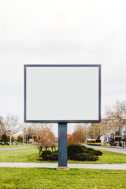 Blank vertical street billboard poster on green grass in the city road