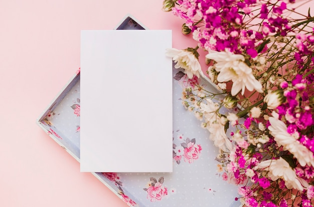 Blank white card and flower bouquet with an empty box on pink background