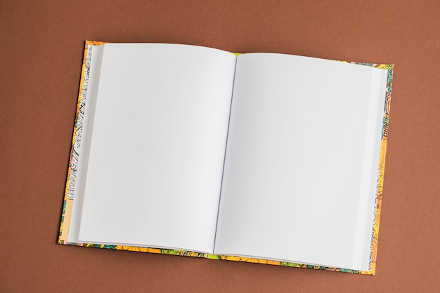 Free photo blank white open textbook on brown background