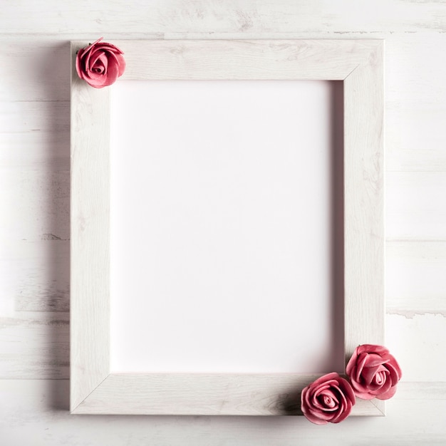 Free photo blank wooden frame with beautiful roses