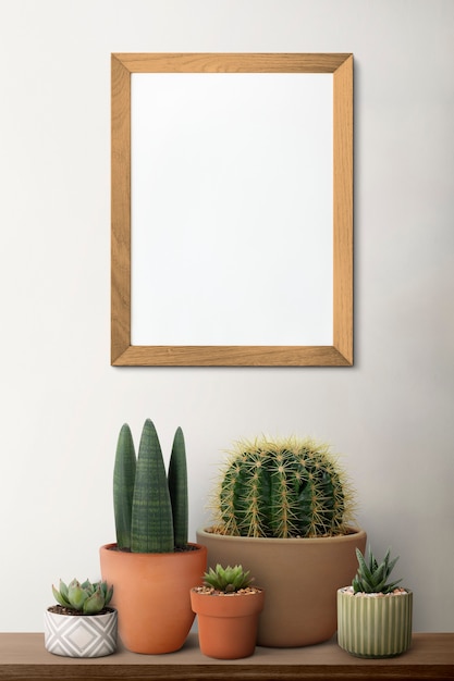 Blank wooden picture frame on a shelf with cactus