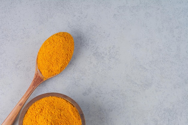 Blended curcumin powder in a wooden spoon. 