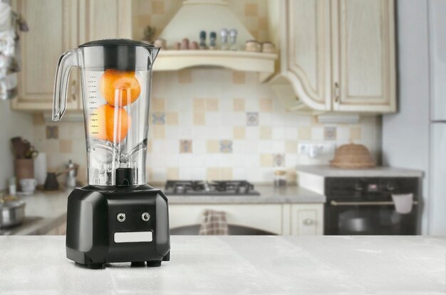 Blender and orange on wooden table in kitchen. Make yourself fresh. The concept of a healthy diet