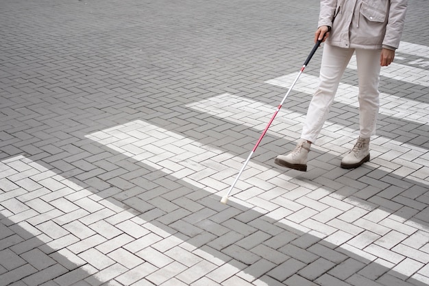 Blind person walking through the city with blind stick