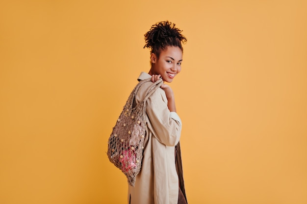 Blithesome woman with string bag looking at front