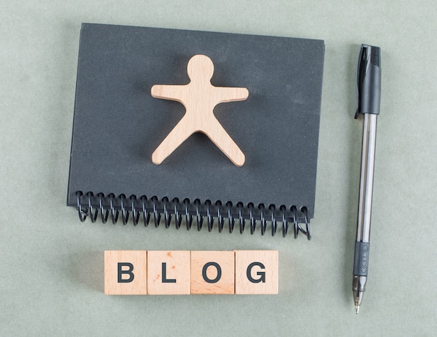 Free photo blog notes concept with wooden blocks, pen and black notebook top view.