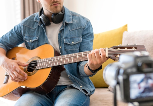 Blogger recording himself while playing guitar