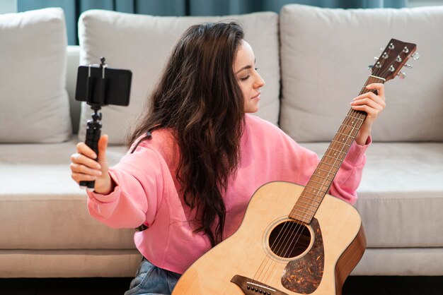 Blogger recording with smartphone her guitar