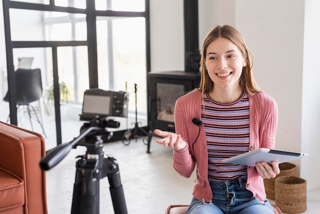 Blogger talking to camera and using tablet