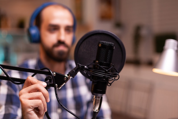 Blogger wearing headphones and talking about lifestyle during podcast Creative online show On-air production internet broadcast host streaming live content recording digital social media communication