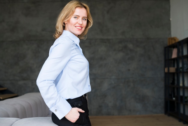 Blond business woman holding hand in pocket