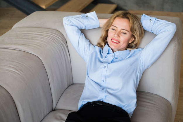 Free photo blond business woman lying on couch