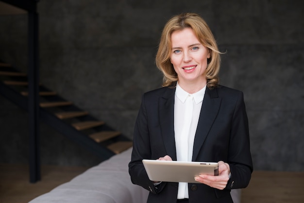 Free Photo blond business woman in suit using tablet