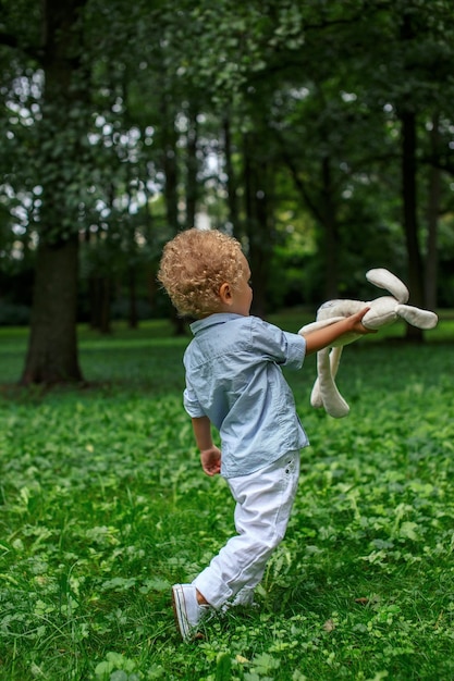 Free photo a blond little child boy playing green park.