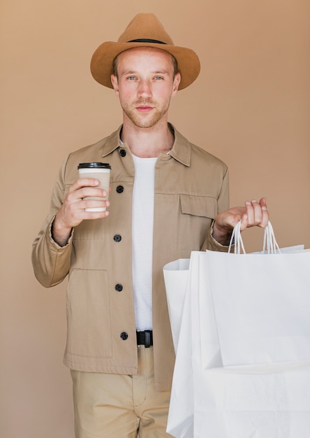 Free Photo blond man with coffee and shopping bags