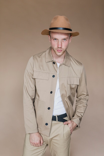 Blond man with hat on a brown background