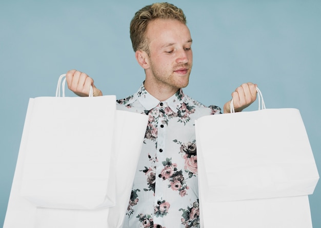 Free Photo blond man with shopping bags on a blue background