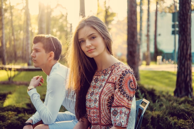 Blond woman and her boyfriend posing in summer park.