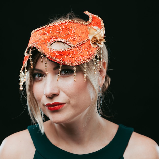 Free Photo blond woman in orange carnival mask 