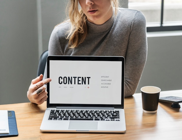 Free photo blond woman pointing at a laptop screen