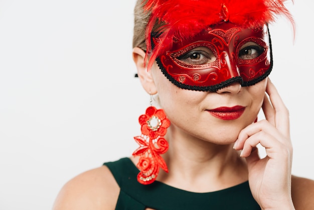 Blond woman in red carnival mask