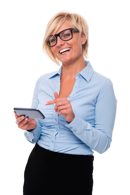 Blonde businesswoman smiling and pointing on mobile phone