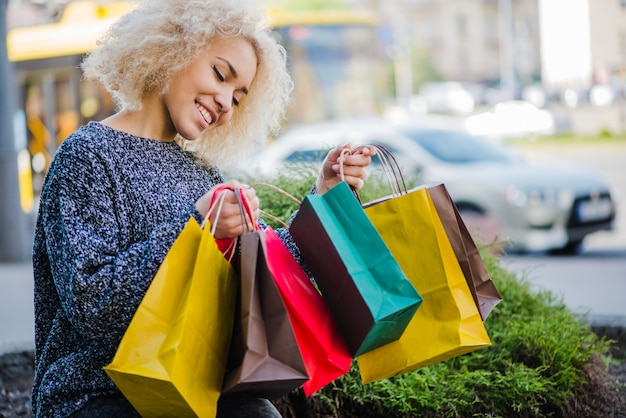 Blonde curly haired girl carrying shopping bags