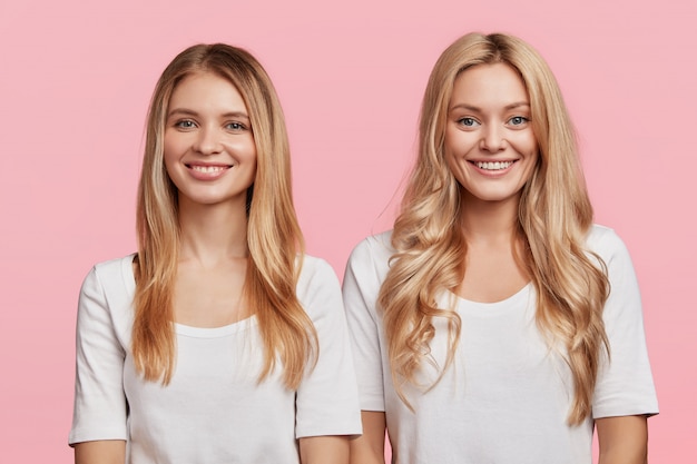 Blonde female friends dressed in white