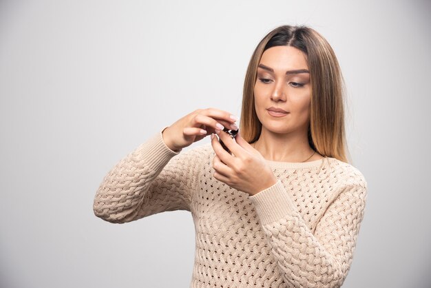 Blonde girl checking photos on polaroid film and feels disappointed