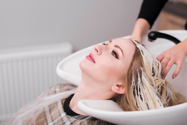 Free photo blonde girl getting her hair done