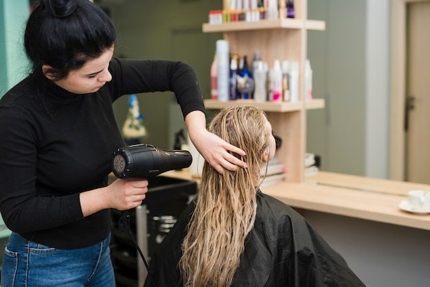 Blonde girl getting her hair dried