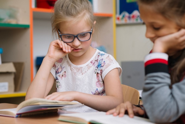 Blonde girl in glasses reading