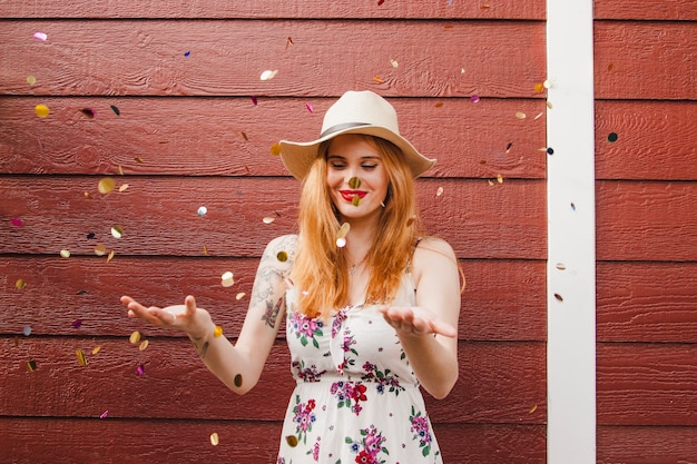 Free photo blonde girl having fun with confetti