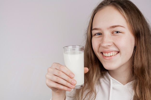 Free photo blonde girl holding a glass of milk