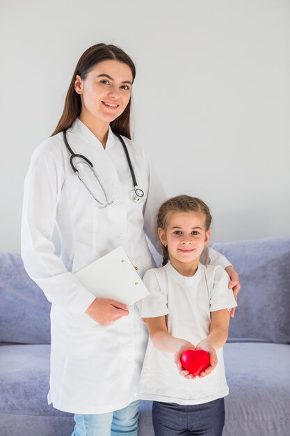 Blonde girl holding heart with doctor