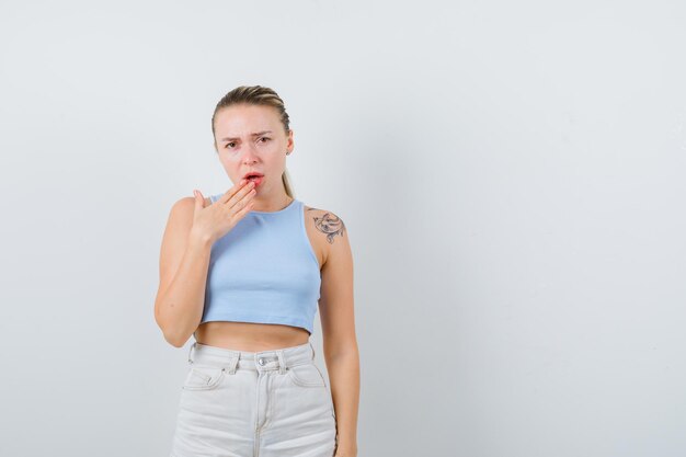 Blonde girl is coughing on white background