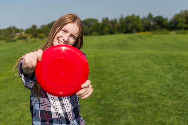 Free photo blonde girl posing with a red frisbee