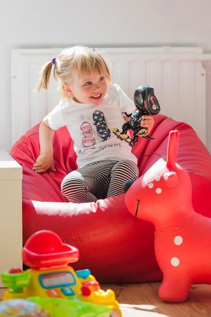 Free photo blonde girl sitting on chair smiling