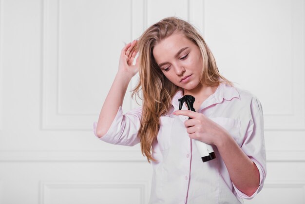 Blonde girl taking care of her hair