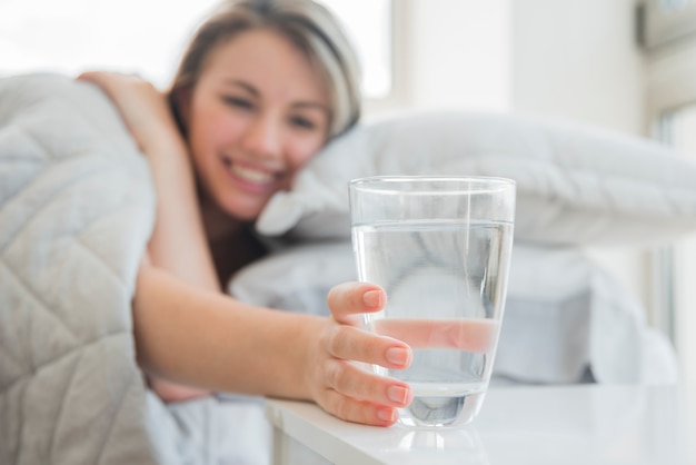 Blonde girl taking glass of water